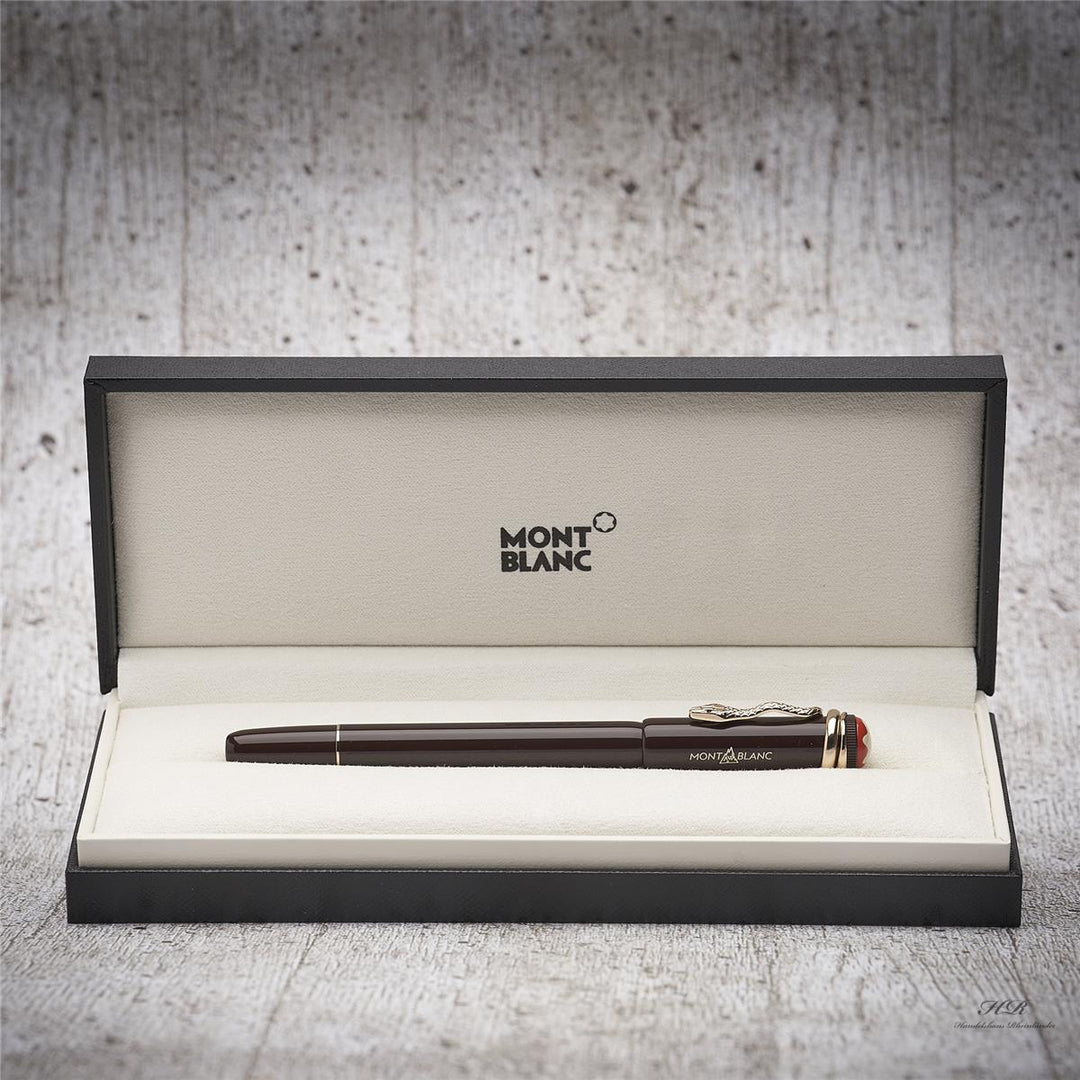Brauner Rollerball liegt in offener Originalbox vor grauem Hintergrund in Holzoptik
