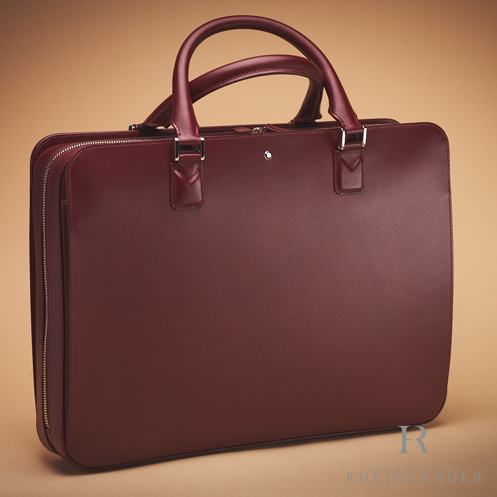 rote Montblanc Ledertasche mit Tragegriffen vor beigem Hintergrund