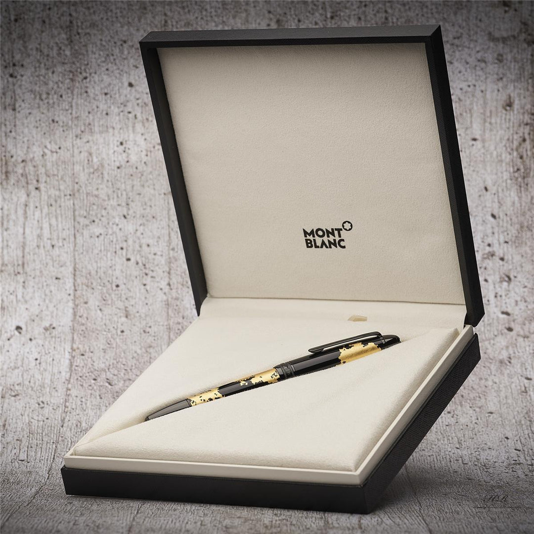 Schwarzer Füller mit Golddetails liegt in halb aufgestellter, offener Originalbox vor grauem Holzoptik-Hintergrund