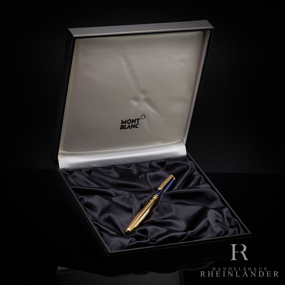 Goldenes Schreibgerät mit blauer Kappe in Originalbox liegend von schräg oben vor schwarzem Hintergrund fotografiert