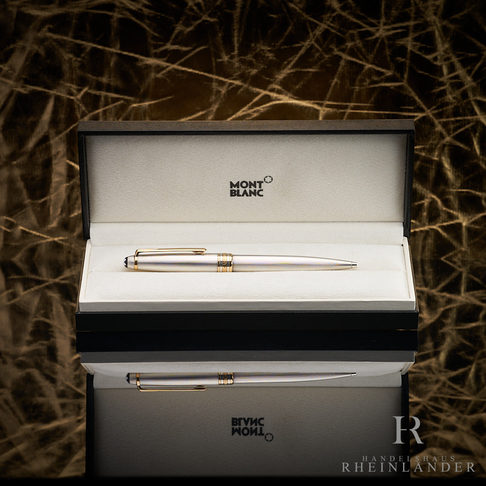 Silberner Kugelschreiber in offener Originalbox liegend vor goldenem Knitteroptik-Hintergrund