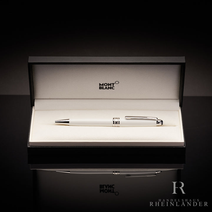 Weisser Kugelschreiber in offener Originalbox liegend vor dunkelgrauem Hintergrund