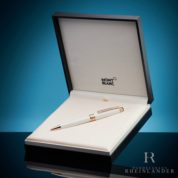 Weisser Kugelschreiber mit goldenen Beschlägen in offener Originalbox vor blauem Hintergrund fotografiert