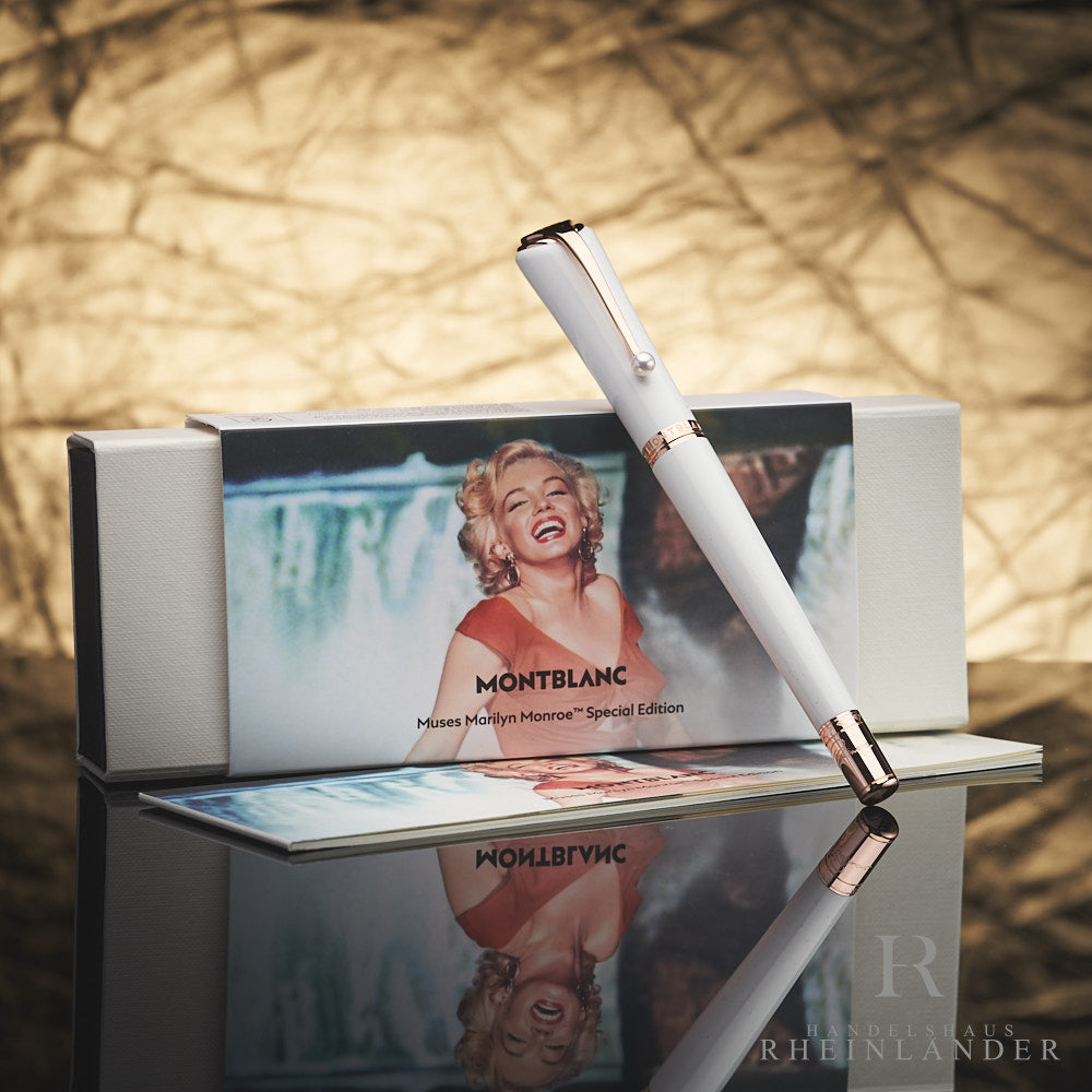 Weißer Montblanc Muses Marilyn Monroe Pearl Rollerball mit rotgoldenen Beschlägen lehnt an Originalverpackung
