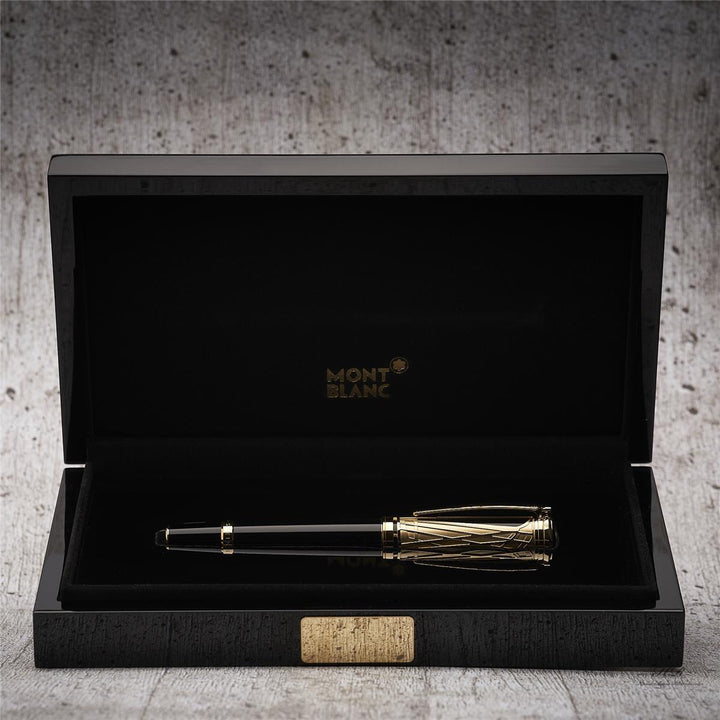 Schwarzer Füller mit goldener Kappe liegt in offener Originalbox vor hellgrauem Hintergrund in Holzoptik