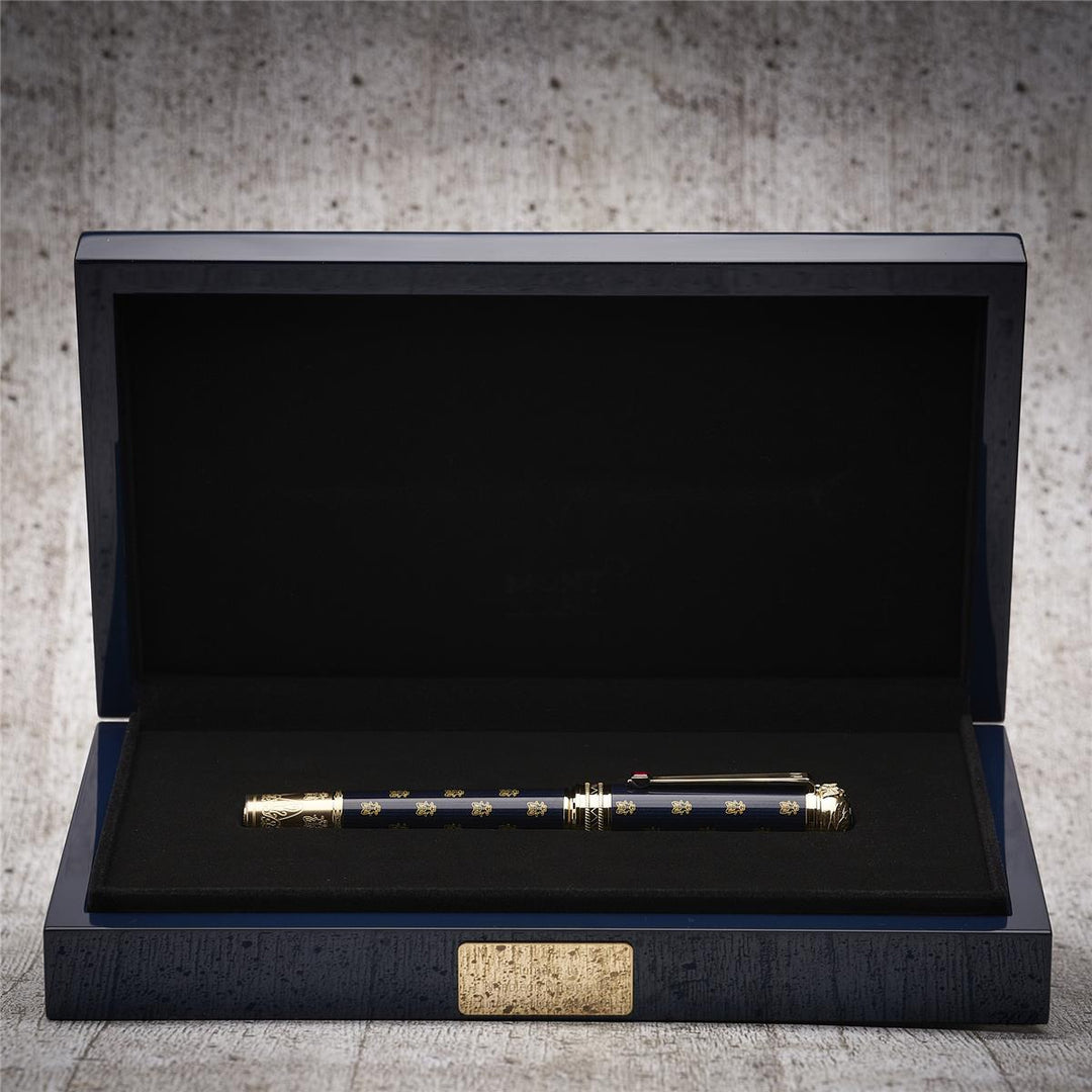 Dunkelblauer Montblanc Füller liegt in offener Originalbox vor hellgrauem Hintergrund in Holzoptik