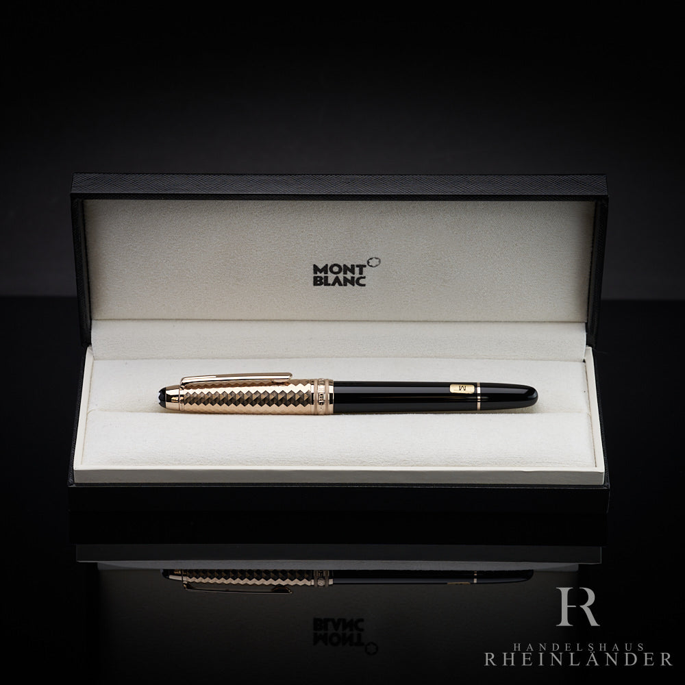 Schwarzer Füller mit goldener Musterkappe liegt in offener Originalbox vor dunkelgrauem Hintergrund