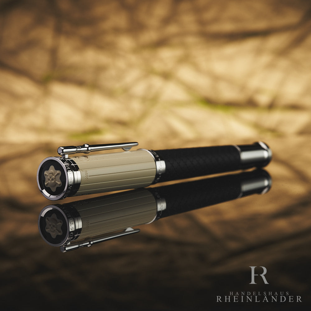 Schwarzer Rollerball liegt mit beiger Kappe voran zur Kamera, das Montblanc Logo mit Totenkopf-Intarsie klar zu sehen