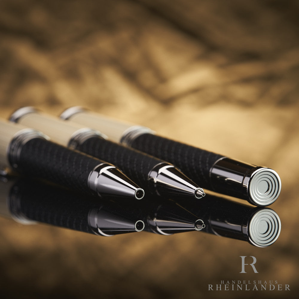 Drei Schreibgeräte schräg nebeneinander aufgereiht, silberner Konus bzw. Schreibspitze zur Kamera 