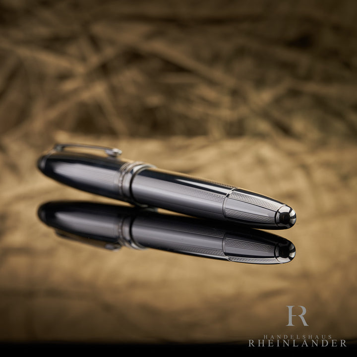 Konus mit Guilloche des Montblanc LeGrand Pure Silver Solitaires liegend vor goldenem Hintergrund