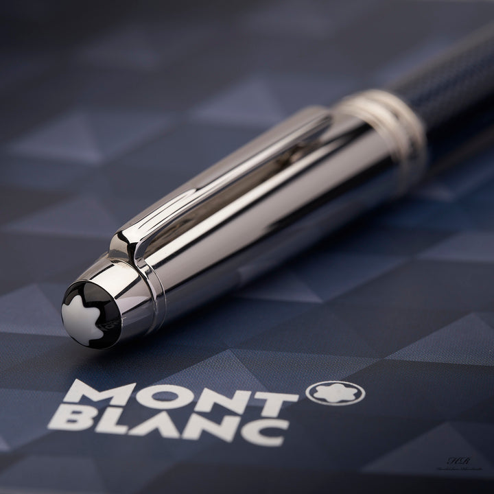 Nahaufnahme von silberner Kappe und Montblanc Logo am Kappenkopf, liegend auf Originalverpackung
