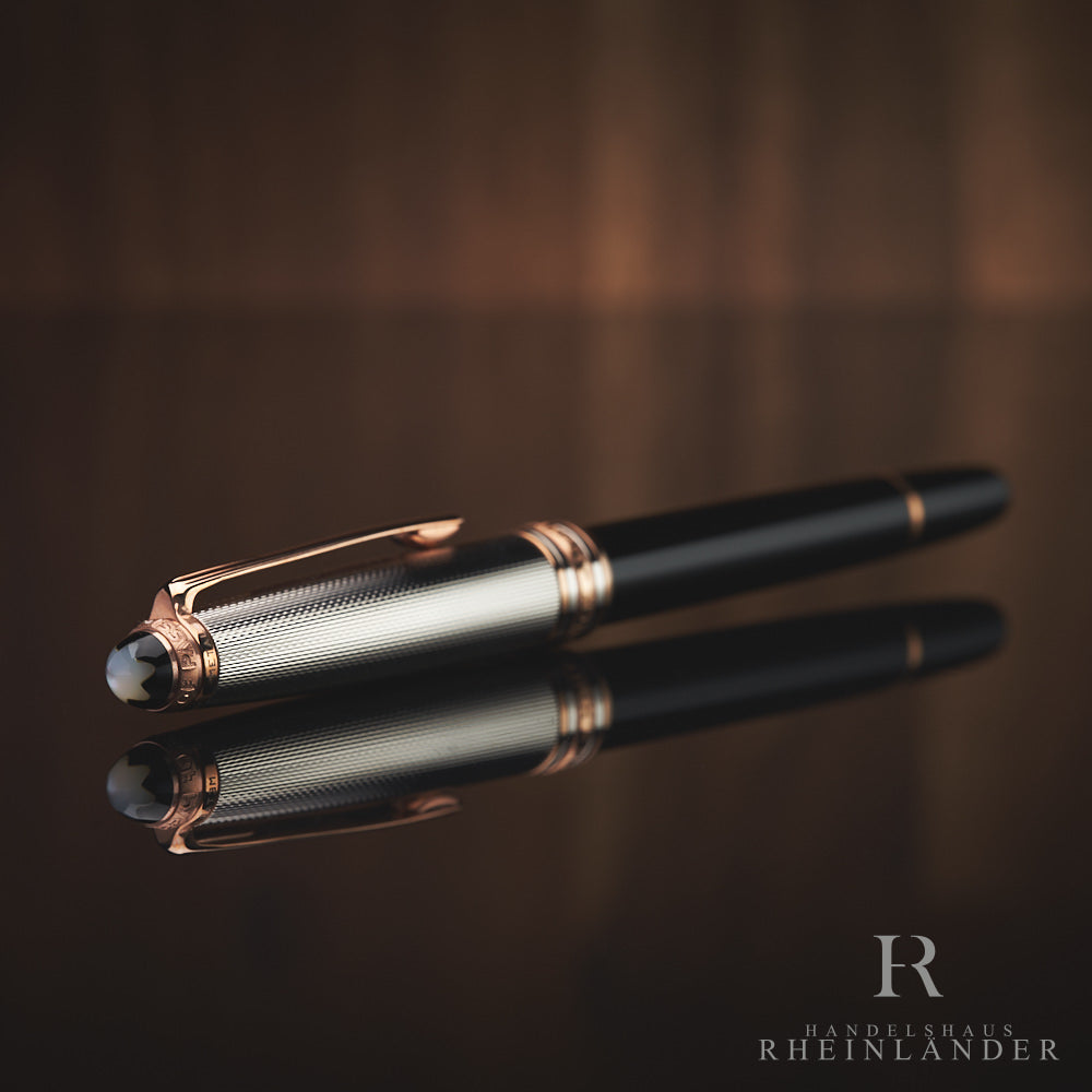 Schwarzer Rollerball mit silberner Kappe und rotgoldenen Beschlägen liegt mit Perlmutt-Emblem schräg zur Kamera gerichtet