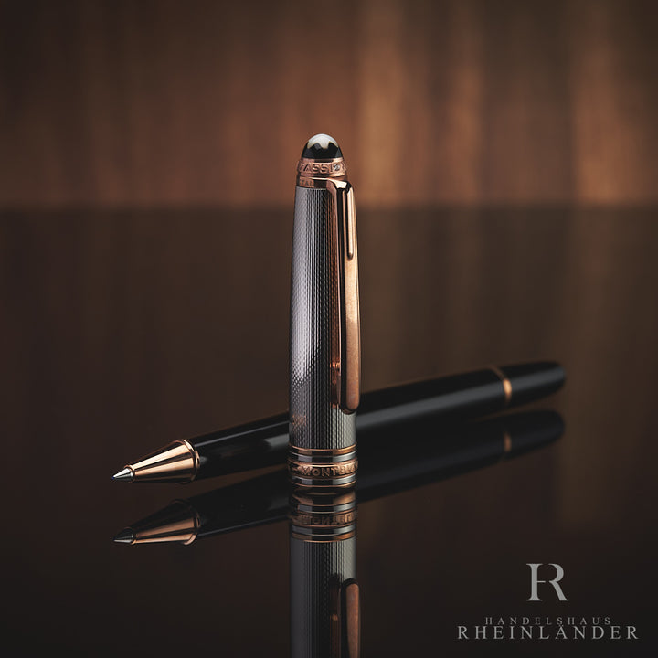 Schwarzer Rollerball liegt offen auf spiegelnder Oberfläche, die silberne Kappe davor aufgestellt.