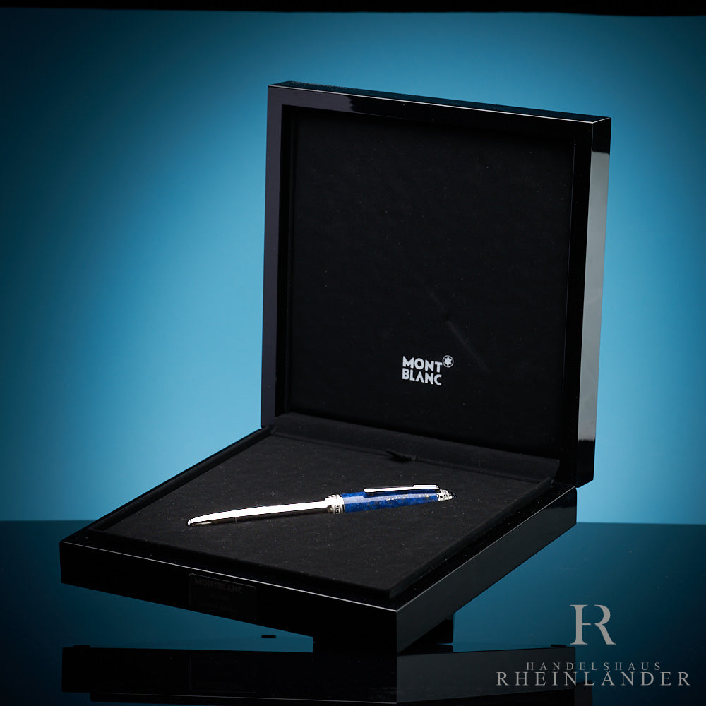 Weißgold-Füller von Montblanc mit blauer Kappe in offener, schwarz hochglanz lackierter Originalbox vor blauem Hintergrund