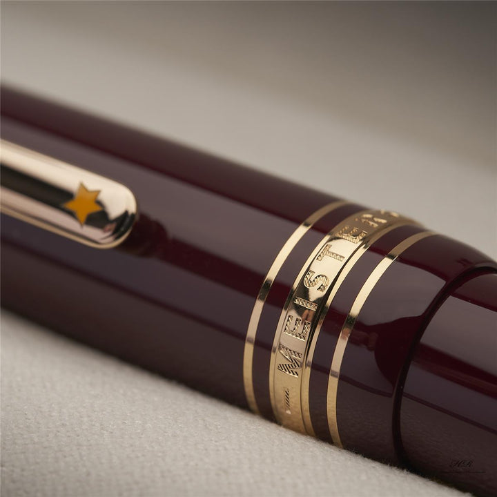 goldene Kappenringe am roten Montblanc Petit Prince Planet LeGrand Rollerball mit Gravuren und gelben Stern auf dem Clip