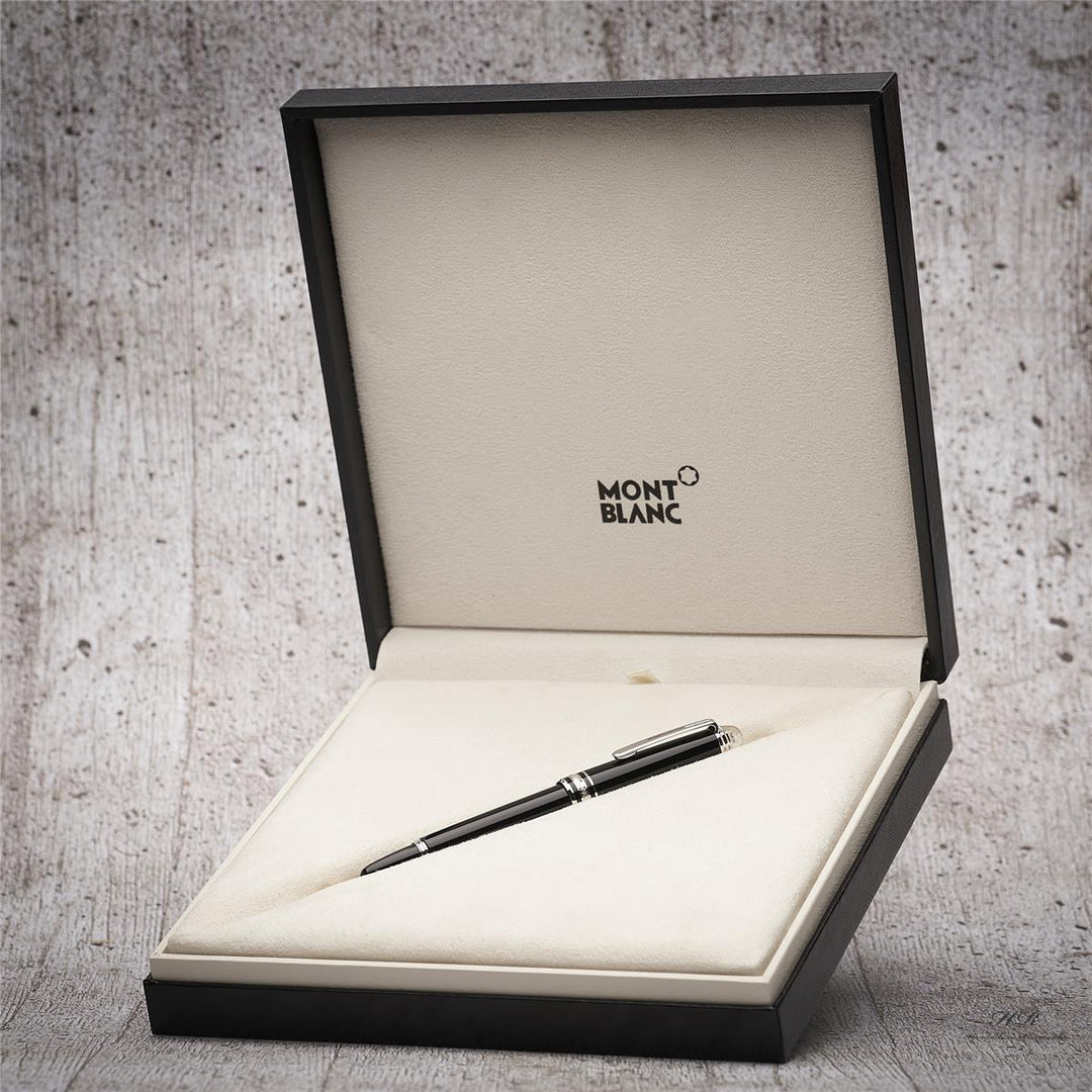 Schwarzer Füller liegt in edler Montblanc Geschenkbox vor grauem Holzoptik-Hintergrund