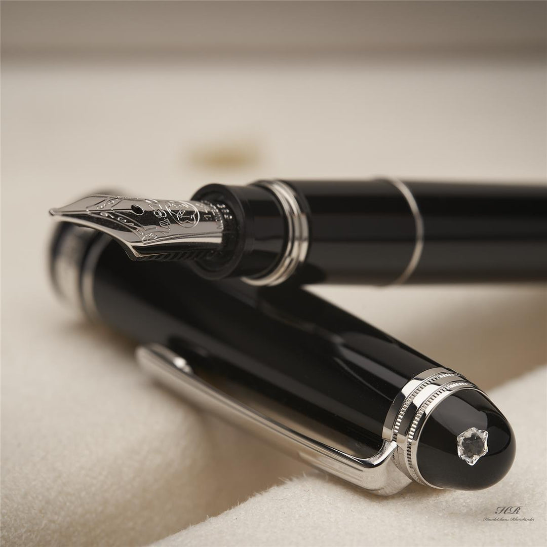 Konus des schwarzen Füllers liegt auf dessen Kappe, die Feder des Füllfederhalters ist deutlich zu sehen