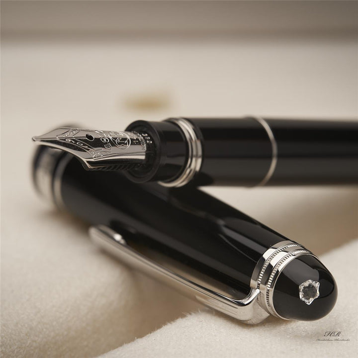 Konus des schwarzen Füllers liegt auf dessen Kappe, die Feder des Füllfederhalters ist deutlich zu sehen