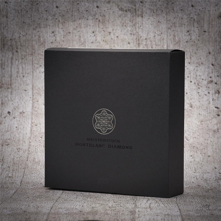 Einzelaufnahme der schwarzen Umverpackung des Füllfederhalters vor grauem Hintergrund in Holzoptik