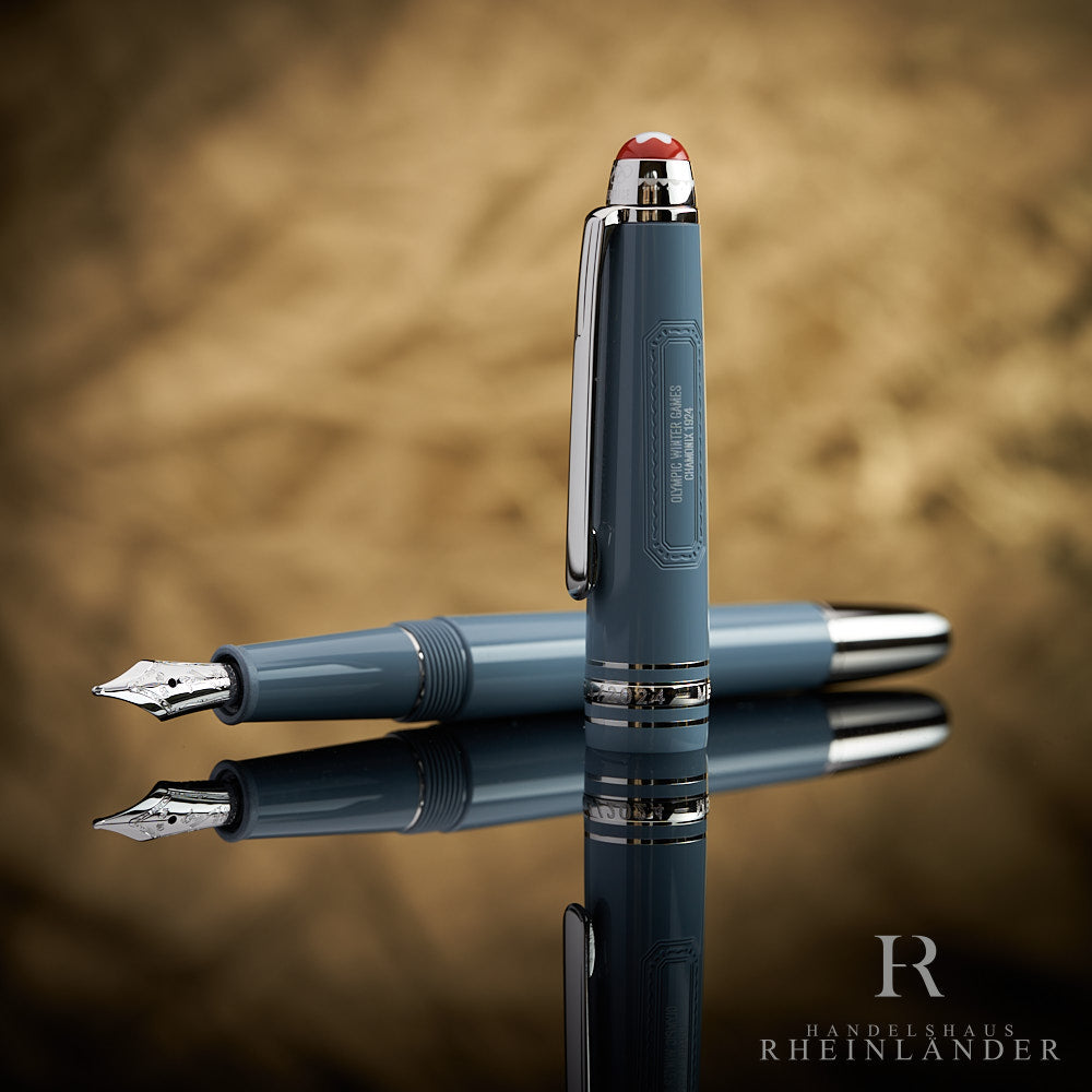 Graublauer Füller liegt geöffnet auf spiegelnder Oberfläche, die Kappe steht vor dem Griffstück postiert