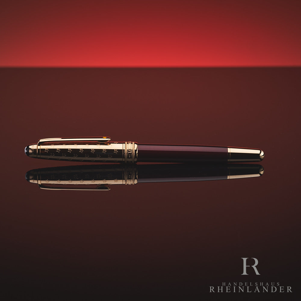 Burgundfarbener Rollerball mit goldener Kappe und Konus liegt horizontal auf spiegelnder Oberfläche vor rotem Hintergrund 