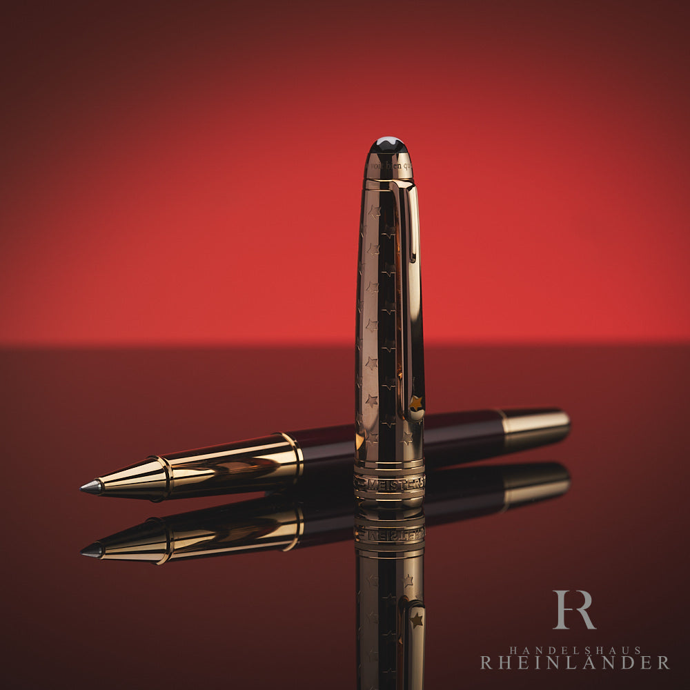 Burgundfarbener Rollerball liegt offen auf spiegelnder Oberfläche, das goldene Griffstück ist zu sehen, die goldene Kappe davor aufgestellt