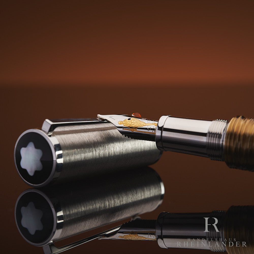 Goldfeder mit Motiv von Gandhi abgelegt auf der silbernem Kappe der Limited Edition 241 von Montblanc