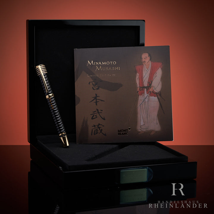 Schwarzer Füller und Editions-Booklet zusammen aufgestellt in offener, schwarzer Montblanc-Box, Hintergrund rot