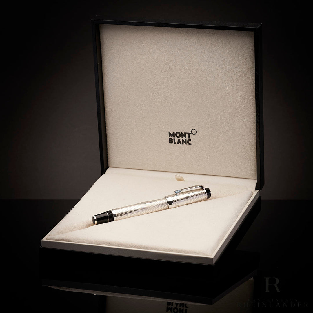 silberner Montblanc Arabesque Azur Rollerball in der Originalverpackung liegend vor schwarzem Hintergrund