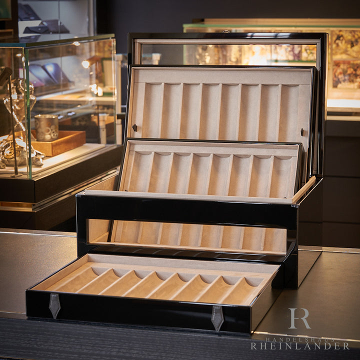 drei Trays aus schwarzer Collectors Box von Montblanc aufgestellt auf schwarzem Schreibtisch mit Vitrinen im Hintergrund
