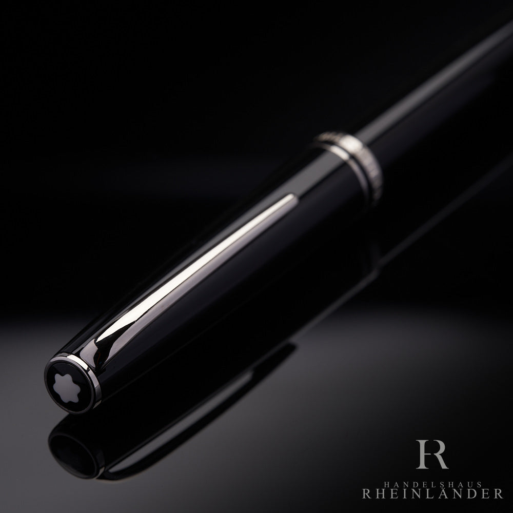 schwarze Kappe mit silbernem Clip und Beschlägen des Montblanc Generation Rollerballs liegend auf schwarzem Tisch
