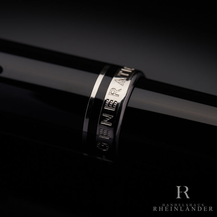 silberne Kappenringe mit Gravur eines schwarzen Montblanc Generation Rollerball in Nahaufnahme