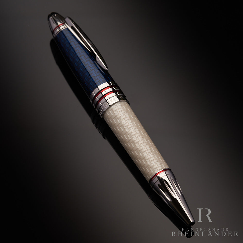 Weißer Kugelschreiber mit blauer Kappe, platinierten Beschlägen und roten Querstreifen liegt auf schwarzem Untegrund