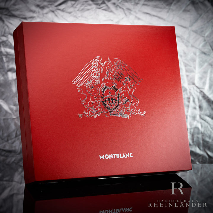 Rote Geschenkverpackung des Montblanc Queen Limited Edition Rollerballs stehend vor silbernem Hintergrund mit Queen Logo
