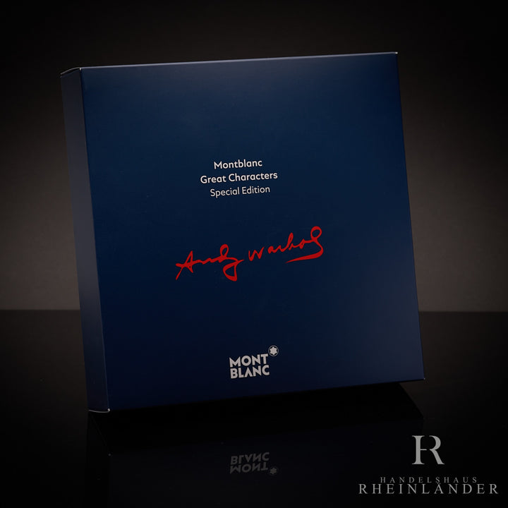 Blaue Umverpackung des Montblanc Great Characters Andy Warhol Rollerballs aufgestellt vor schwarzem Hintergrund