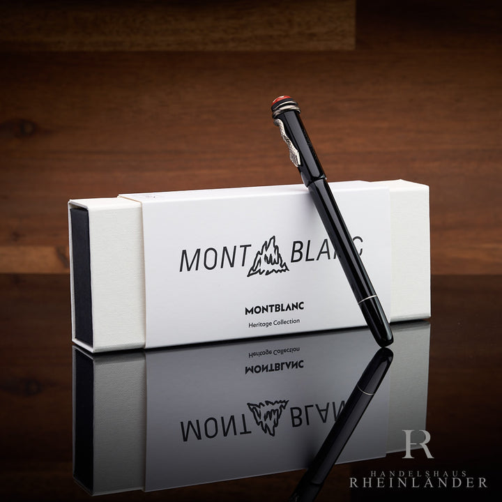 Schwarzer Füller lehnt an weisser Montblanc-Box, Untergrund spiegelnd, Hintergrund braunes Holz