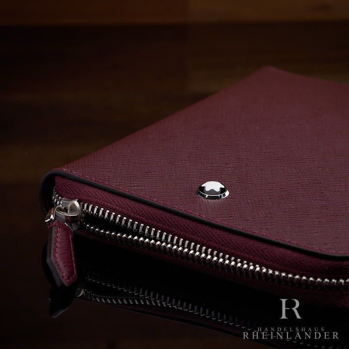 Nahaufnahme des Montblanc Emblems und des offenen Reißverschlusses des Cassis-farbenem 5er Etui