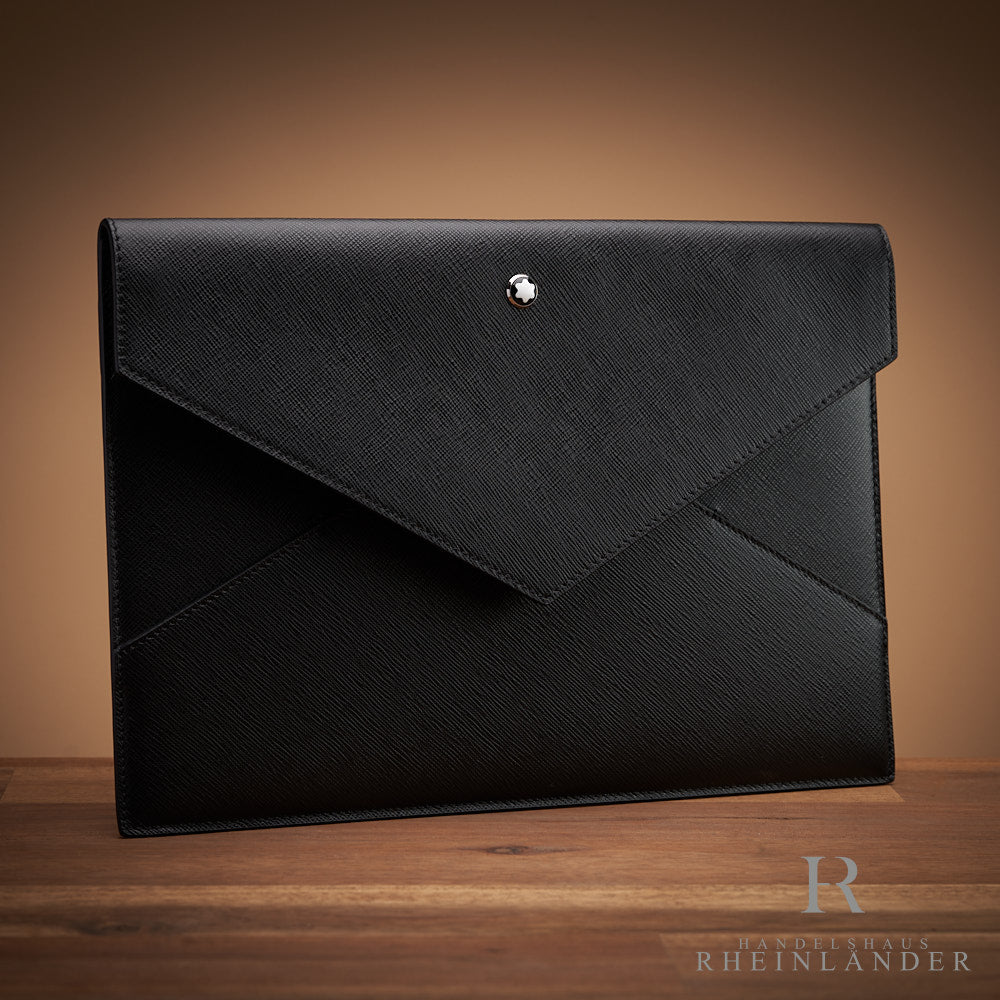 Schwarze Ledertasche von Montblanc in Umschlagform auf Holztisch mit braunem Hintergrund