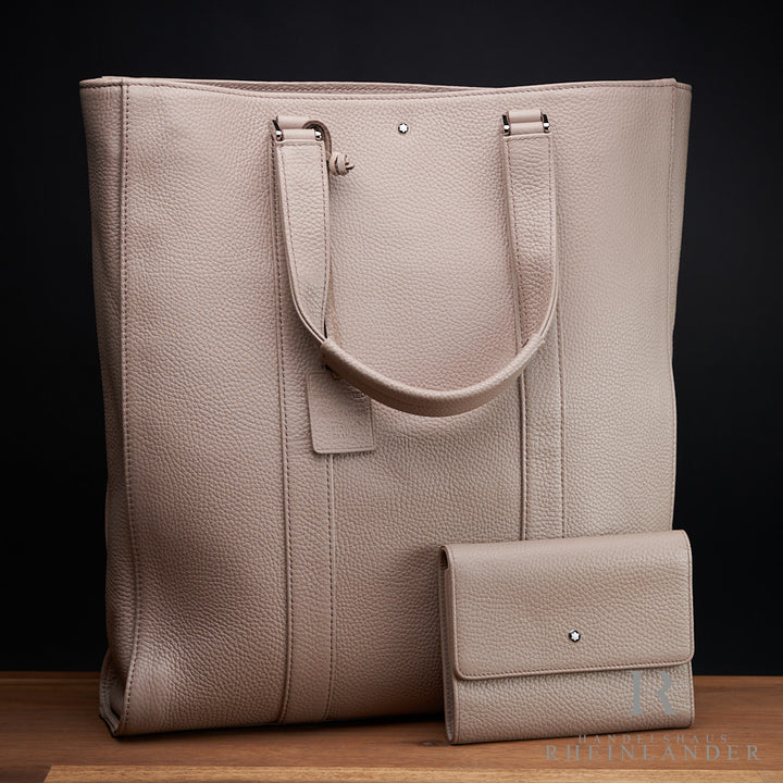 Beige Tote-Bag von Montblanc mit passendem Portemonnaie auf Holzplatte stehend vor schwarzem Hintergrund fotografiert