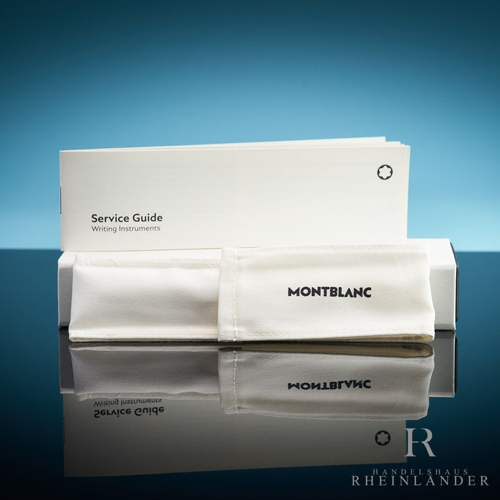 Weiße Originalverpackung mit Baumwollsäckchen und Service Guide von Montblanc vor blauem Hintergrund stehend
