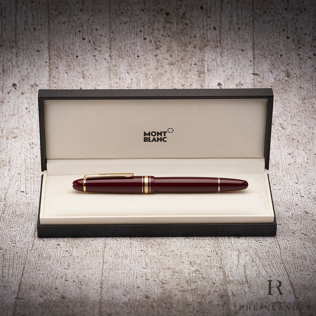 bordeauxroter Montblanc Textmarker mit goldenen Beschlägen in der offenen Originalverpackung liegend vor grauem Hintergund