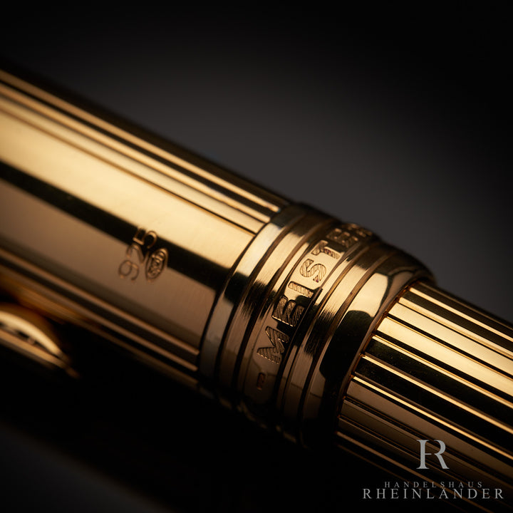 Detailaufnahme der goldenen Beschlagsringe mit Montblanc Gravur zwischen Kappenkopf und Korpus des Füllfederhalters