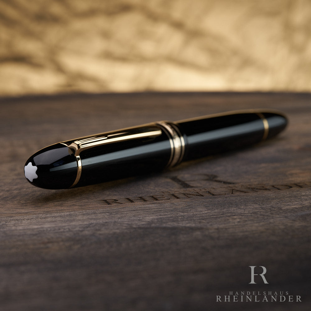 Kappenkopf mit Emblem des schwarzen Montblanc 149 Füllfederhalters mit goldenem Clip und Beschlägen auf Holztisch liegend