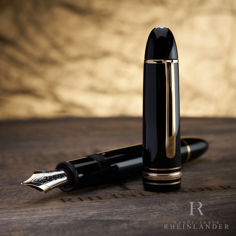 offener Montblanc 149 Füllfederhalter in schwarz mit goldenen Beschlägen Kappe stehend auf Holztisch mit goldenem Hintergrund