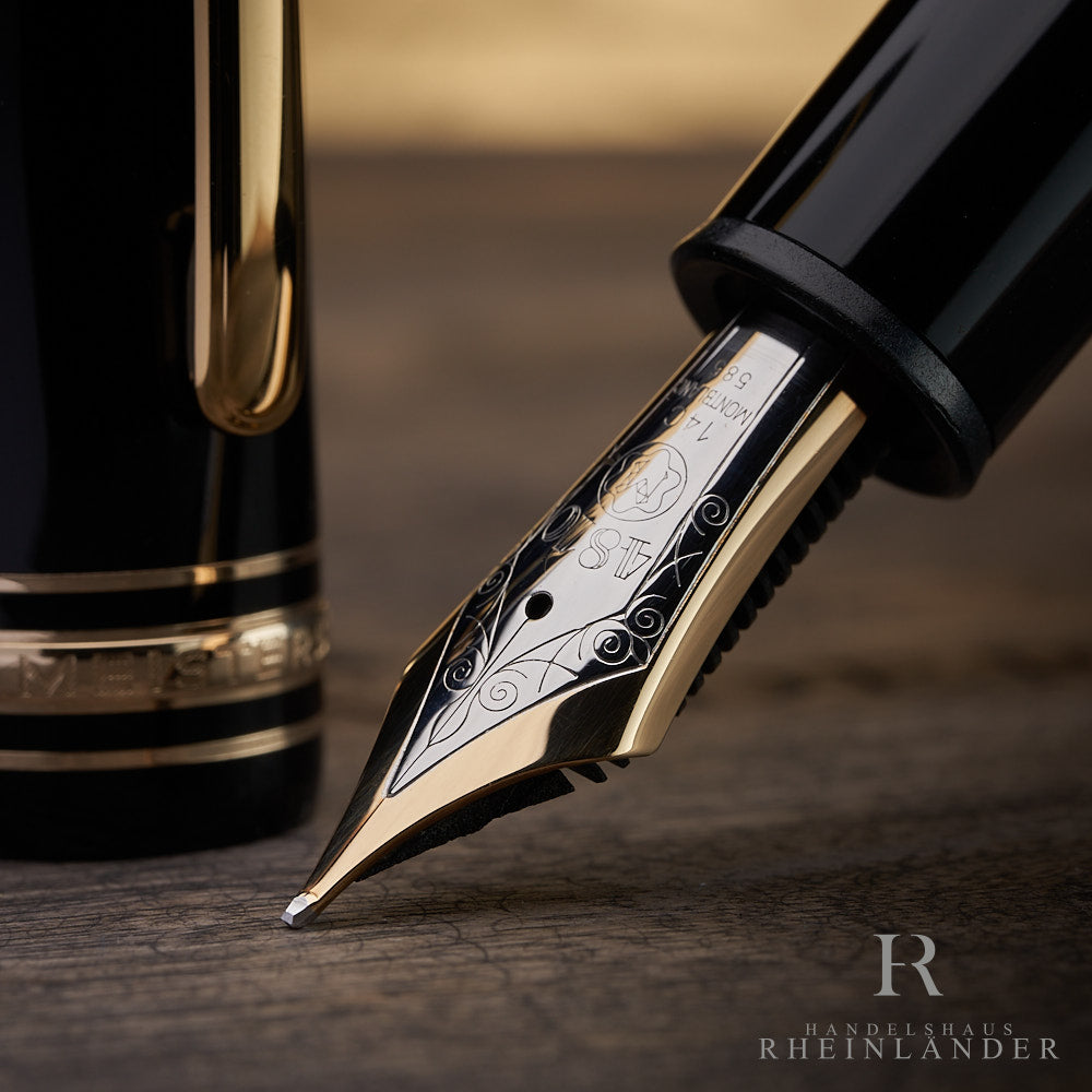 Nahaufnahme der 14 Karat Goldfeder eines schwarzem Montblanc 149 Füllfederhalters auf Holztisch in bicolor