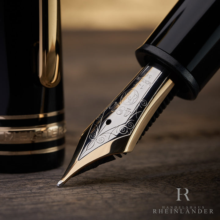 Nahaufnahme der 14 Karat Goldfeder eines schwarzem Montblanc 149 Füllfederhalters auf Holztisch in bicolor