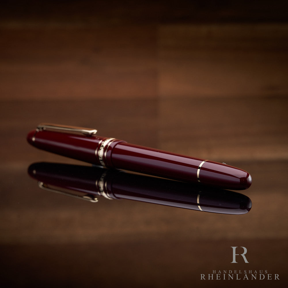 Montblanc Füller in bordeaux liegend mit dem Konusende voran vor hölzernem Hintergrund