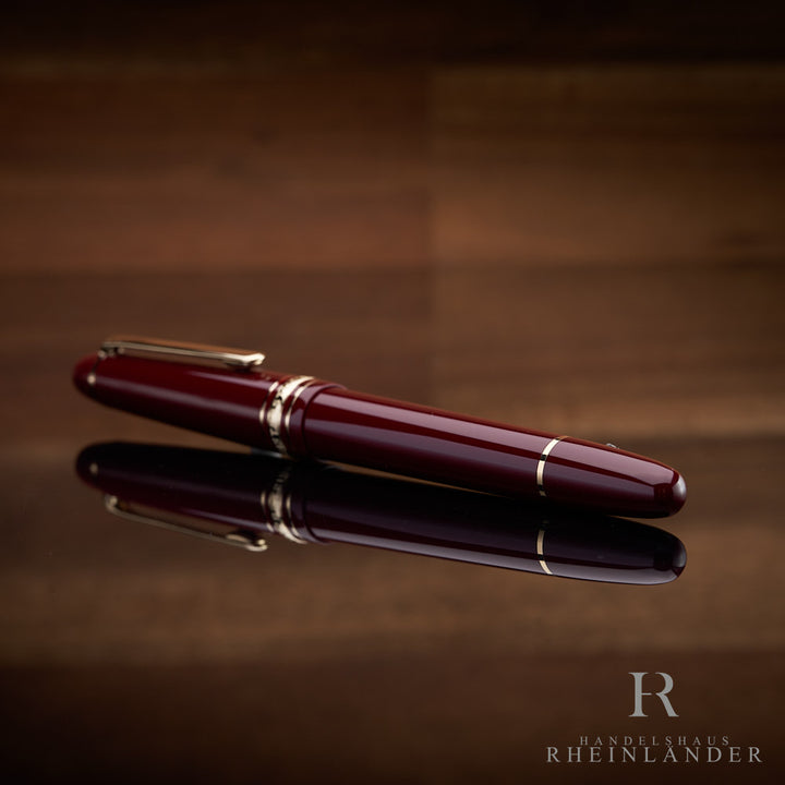 Montblanc Füller in bordeaux liegend mit dem Konusende voran vor hölzernem Hintergrund