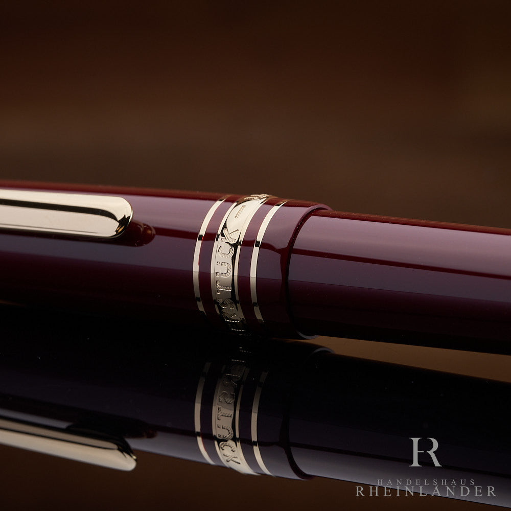 Detailaufnahme der Kappe des burgunderrotem Montblanc Füllers mit Gravur auf den Beschlägen