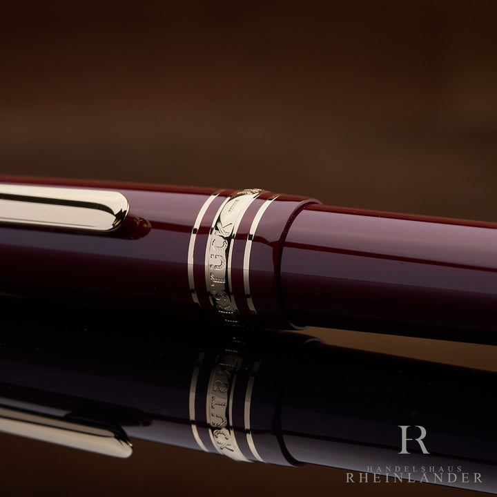 Detailaufnahme der Kappe des burgunderrotem Montblanc Füllers mit Gravur auf den Beschlägen
